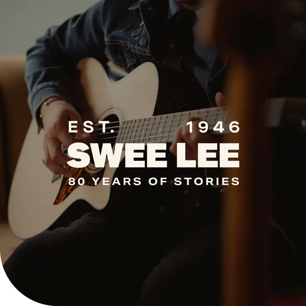 A musician playing an acoustic guitar for Swee Lee's 80th anniversary